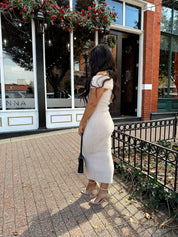 Women wearing cream colored furry off the shoulder midi dress.