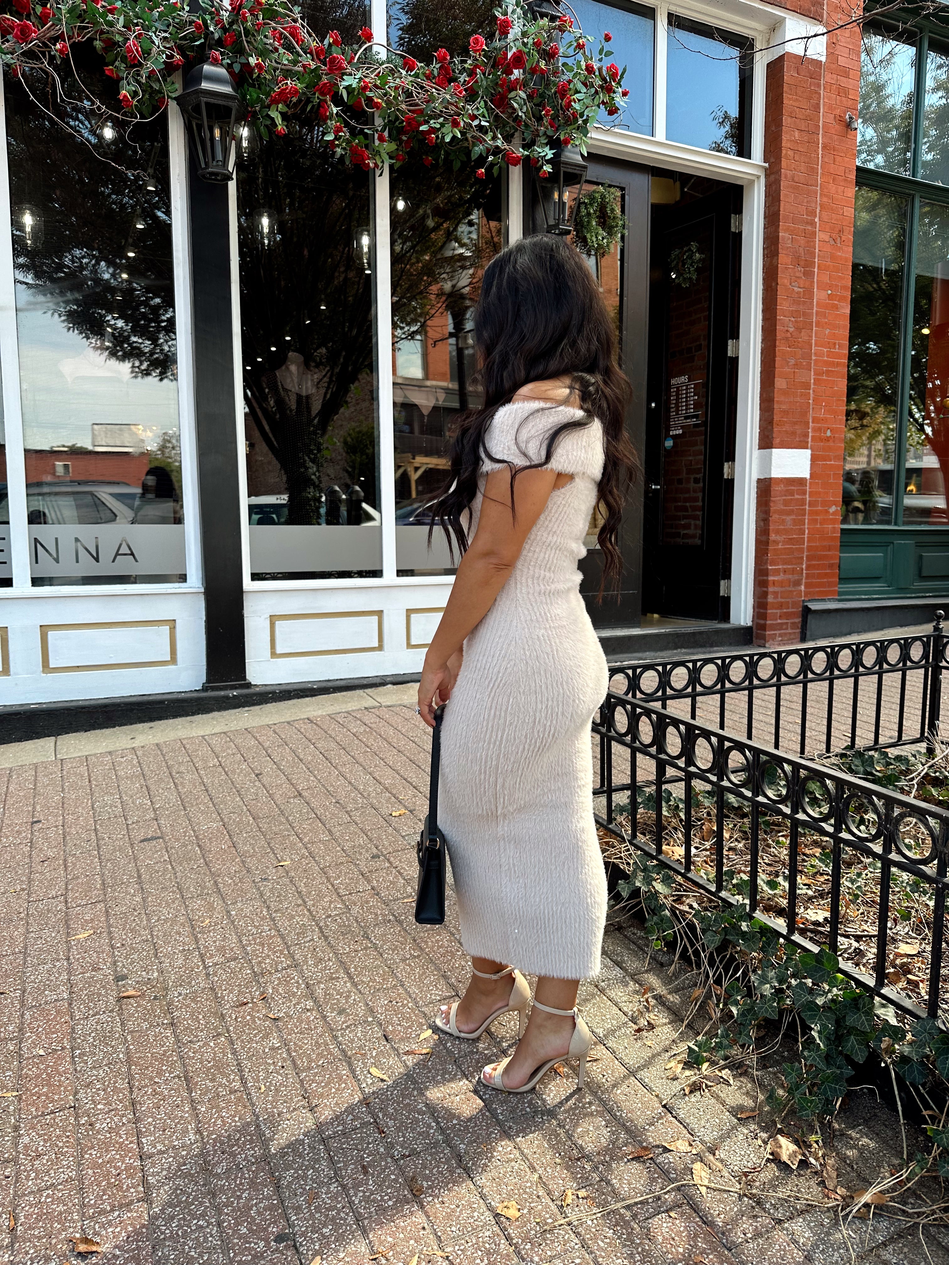 Women wearing cream colored furry off the shoulder midi dress.
