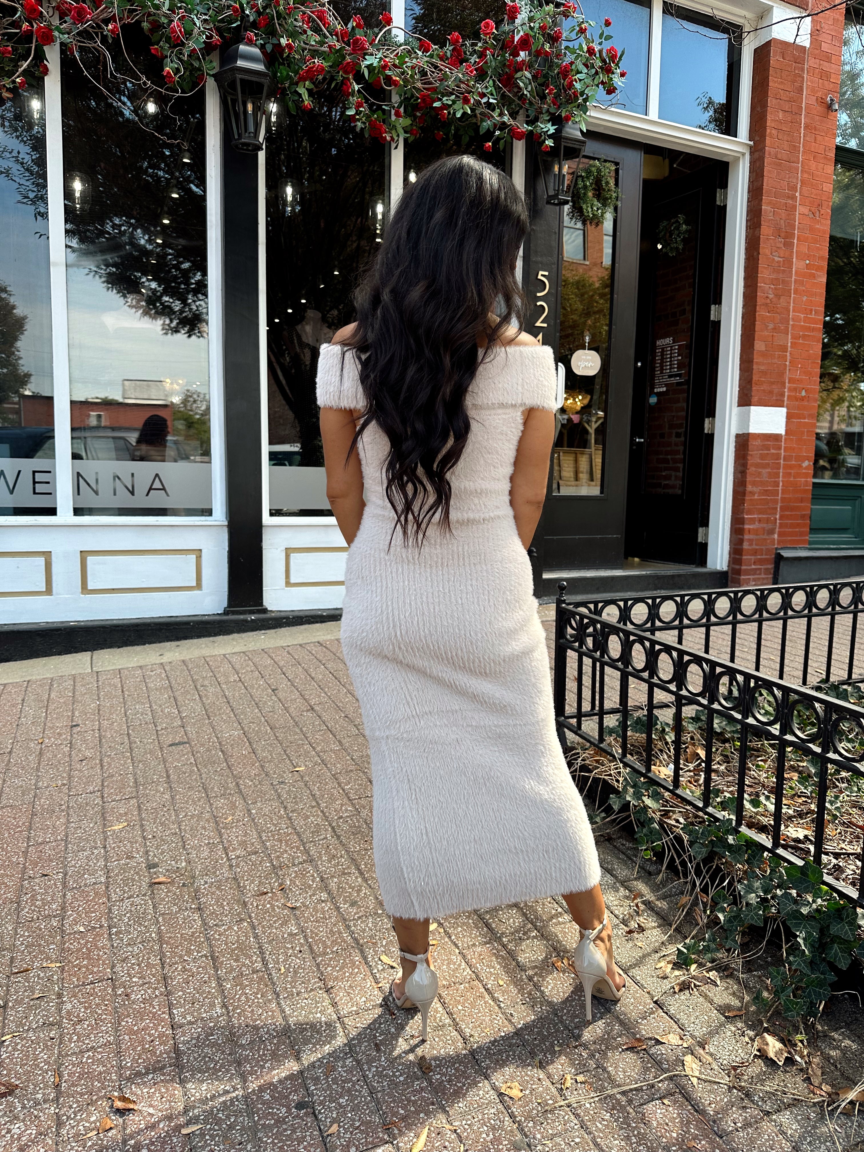Women wearing cream colored furry off the shoulder midi dress.