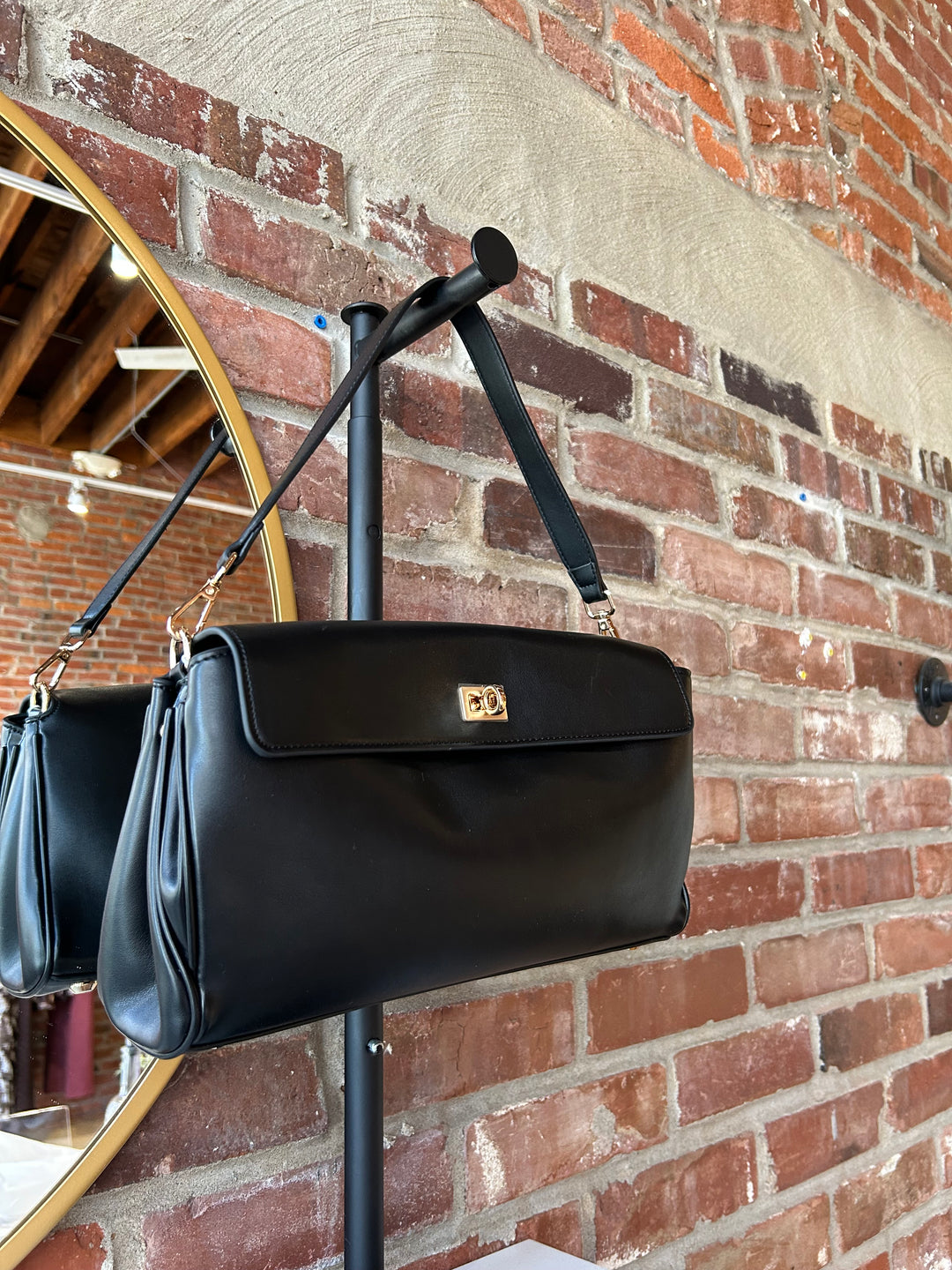 Black leather shoulder bag with metal hardware and removable shoulder strap.