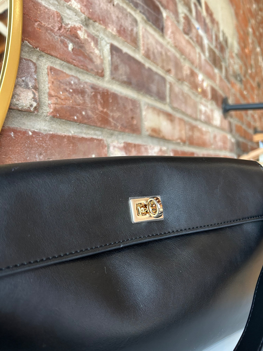Black leather shoulder bag with metal hardware and removable shoulder strap.