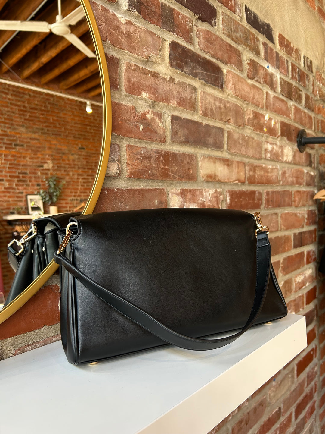 Black leather shoulder bag with metal hardware and removable shoulder strap.