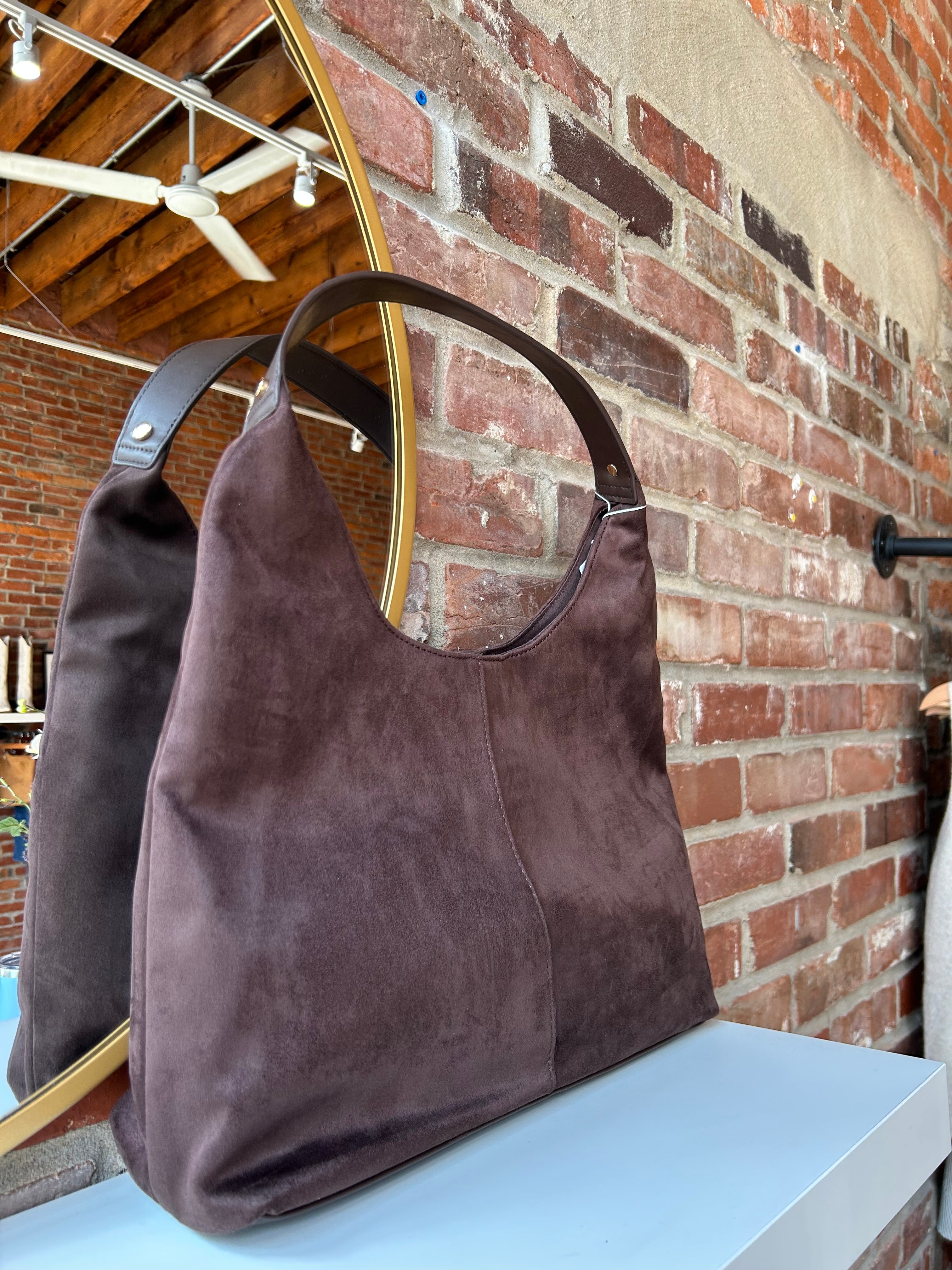 Brown suede shoulder bag with structured handle and roomy minimalist silhouette