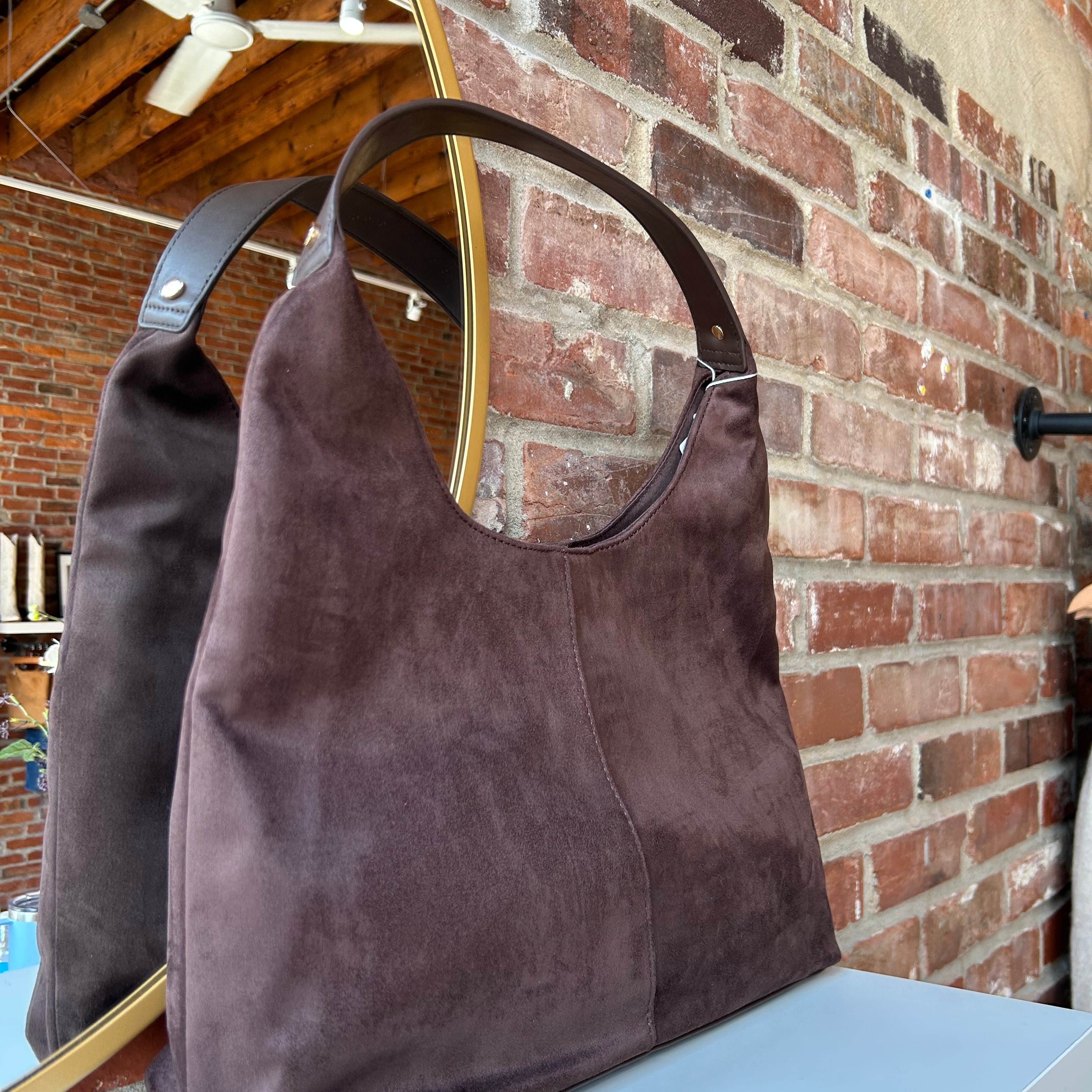 Brown suede shoulder bag with structured handle and roomy minimalist silhouette