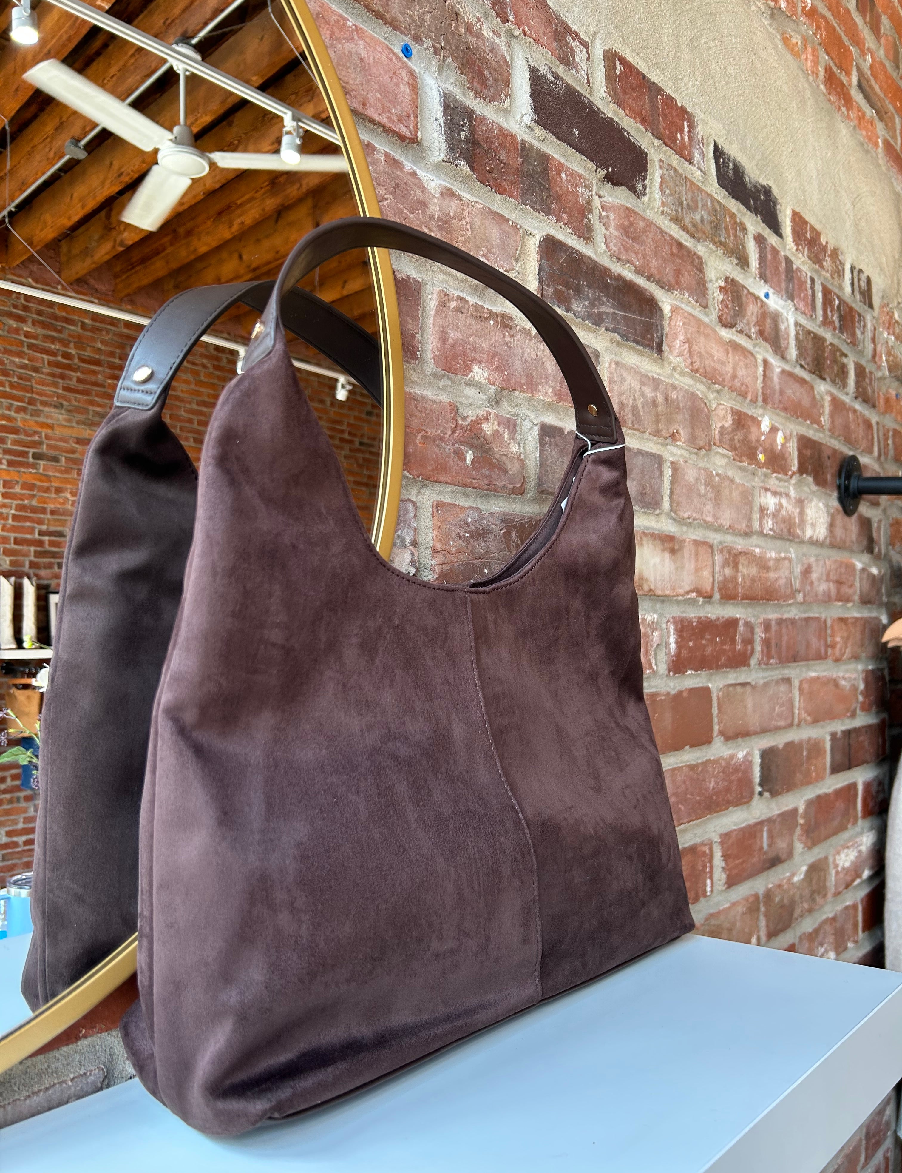 Brown suede shoulder bag with structured handle and roomy minimalist silhouette