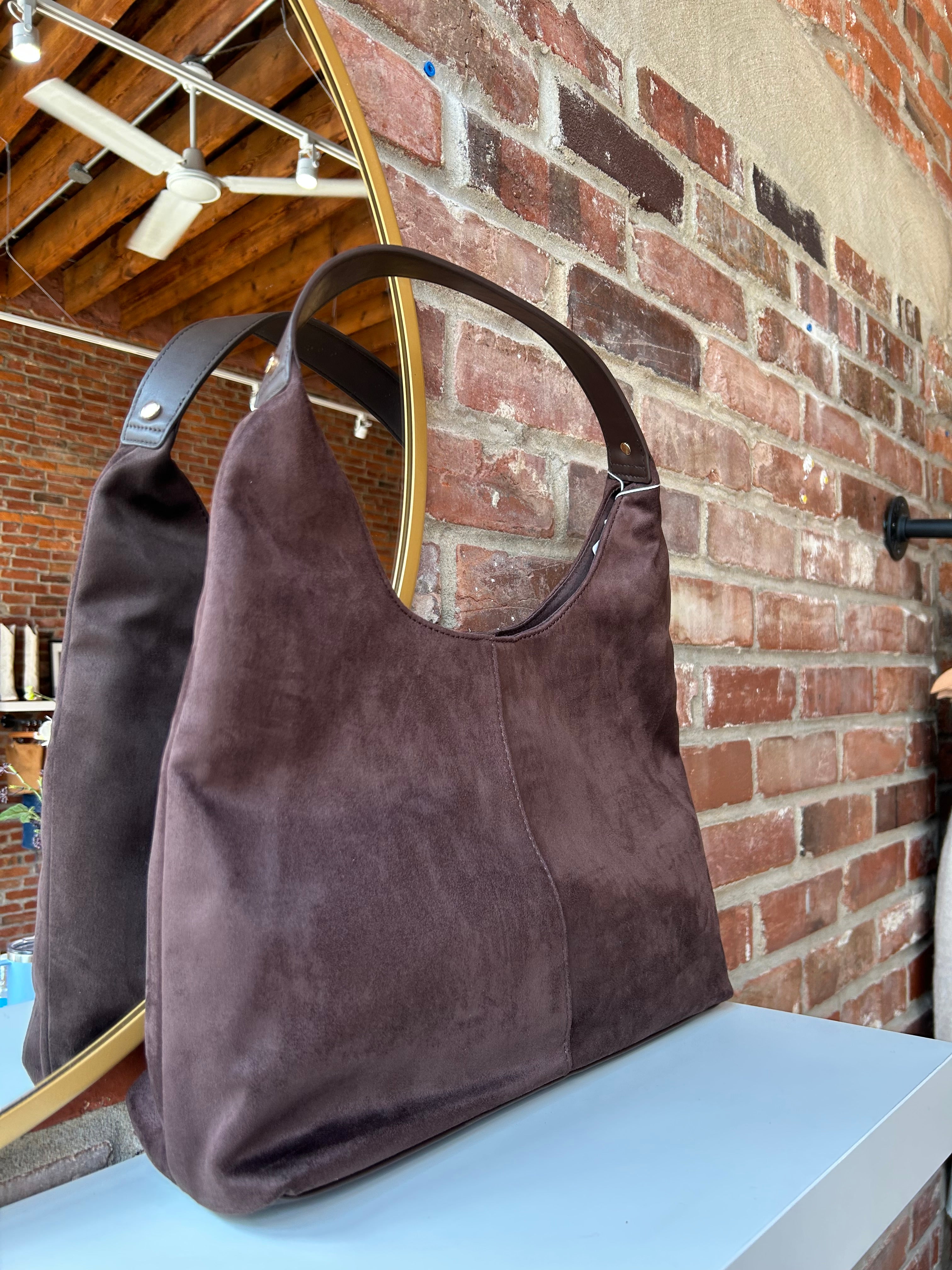 Brown suede shoulder bag with structured handle and roomy minimalist silhouette