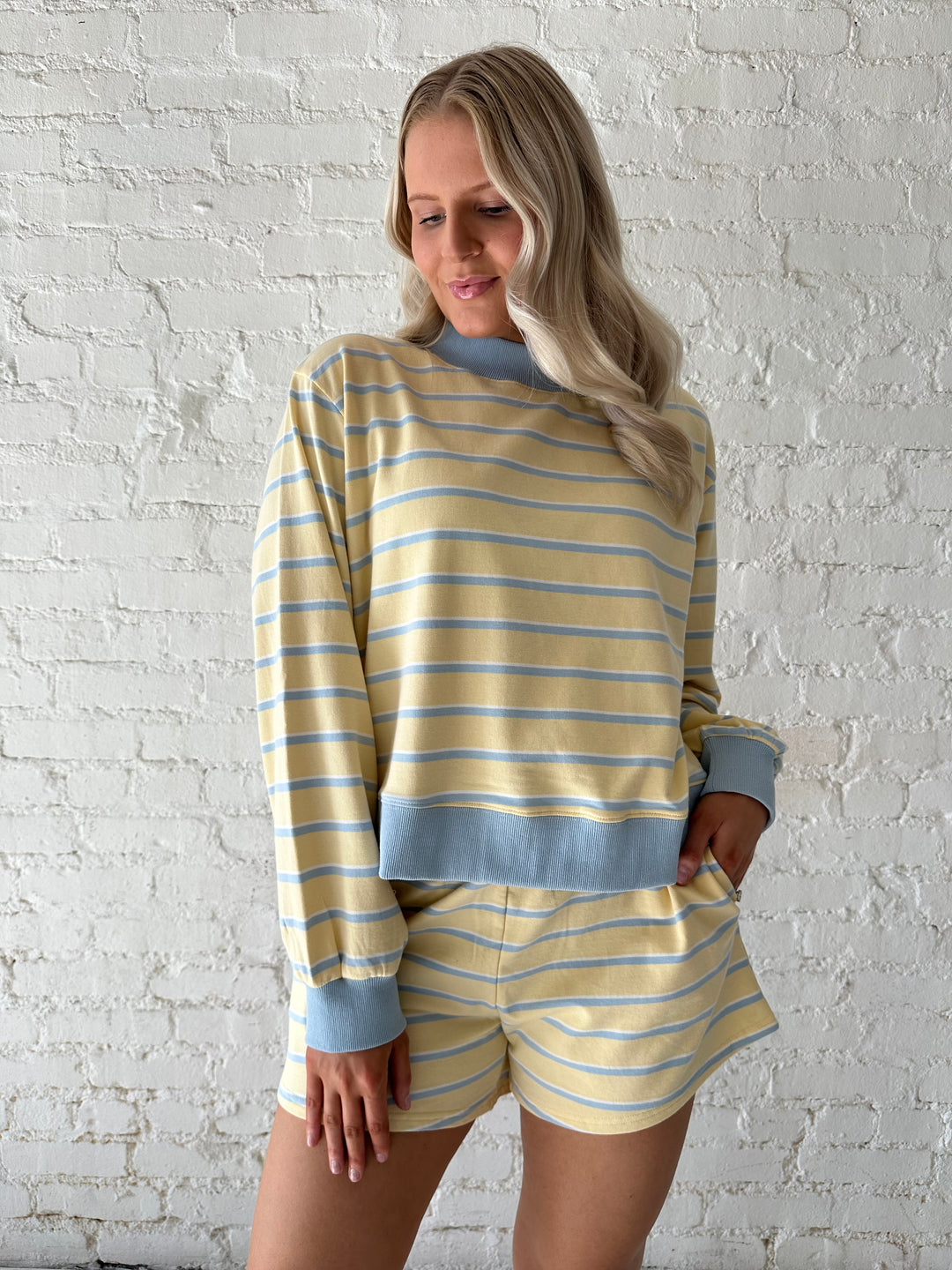 Woman wearing yellow striped two piece lounge set.