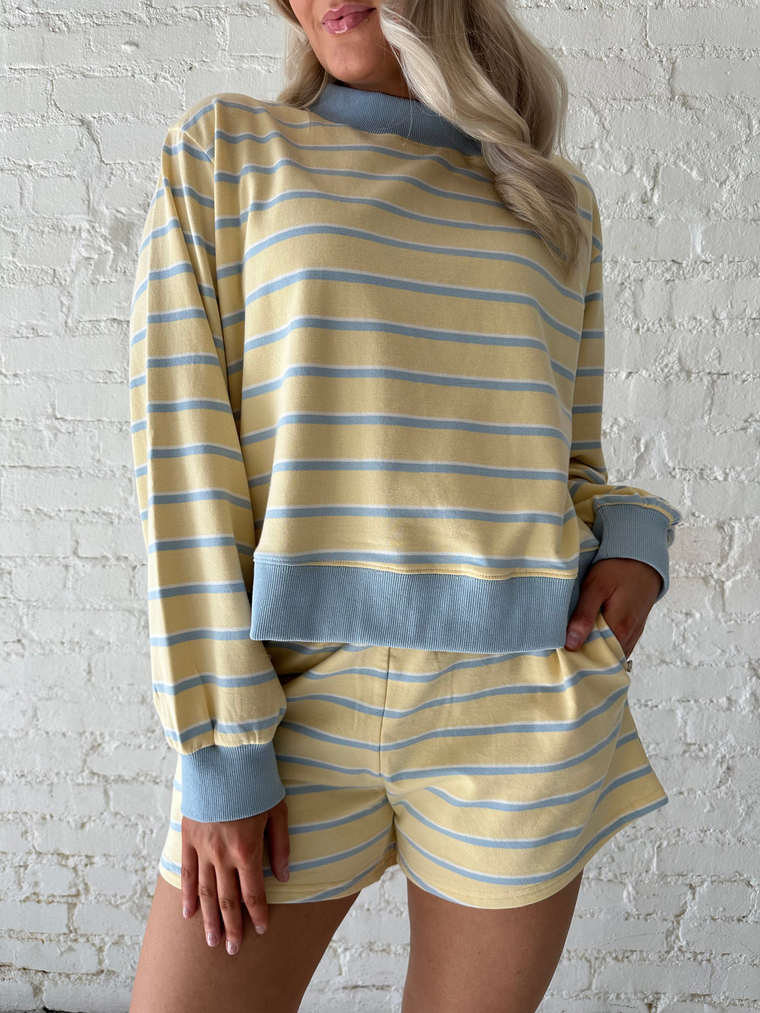 Woman wearing yellow striped two piece lounge set.
