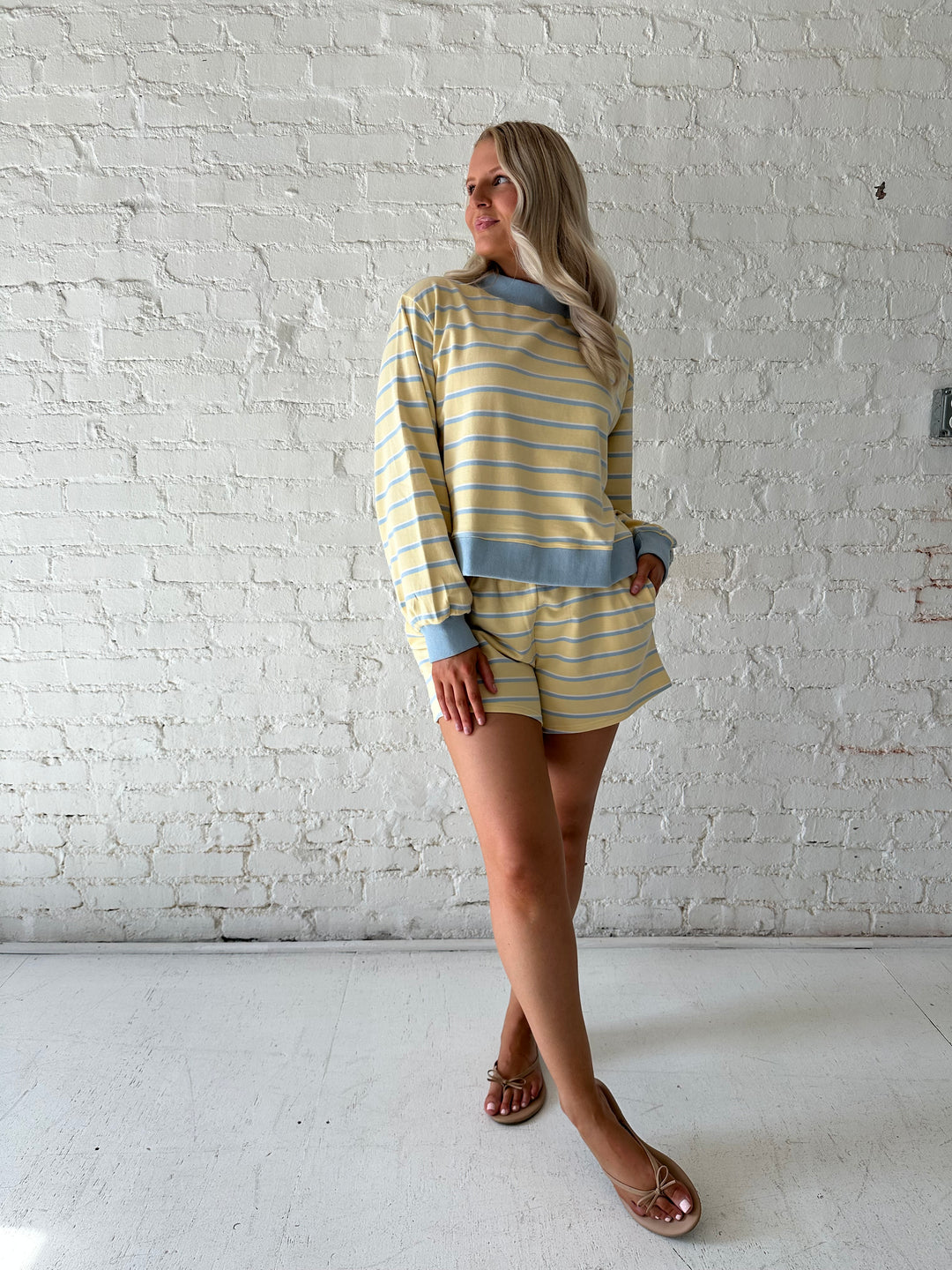 Woman wearing yellow striped two piece lounge set.