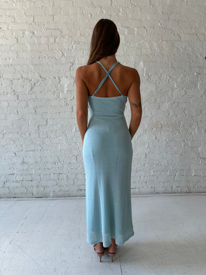 Woman wearing blue shimmer knit maxi dress with criss-cross adjustable back. 