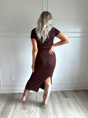 Woman with dark brown two piece knit set with short sleeve button down top, and midi length skirt with back slit.