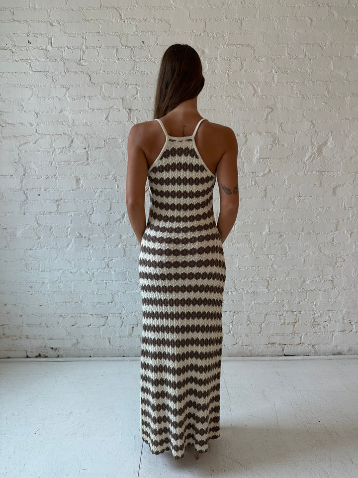 Woman wearing cream and brown striped knit maxi dress.