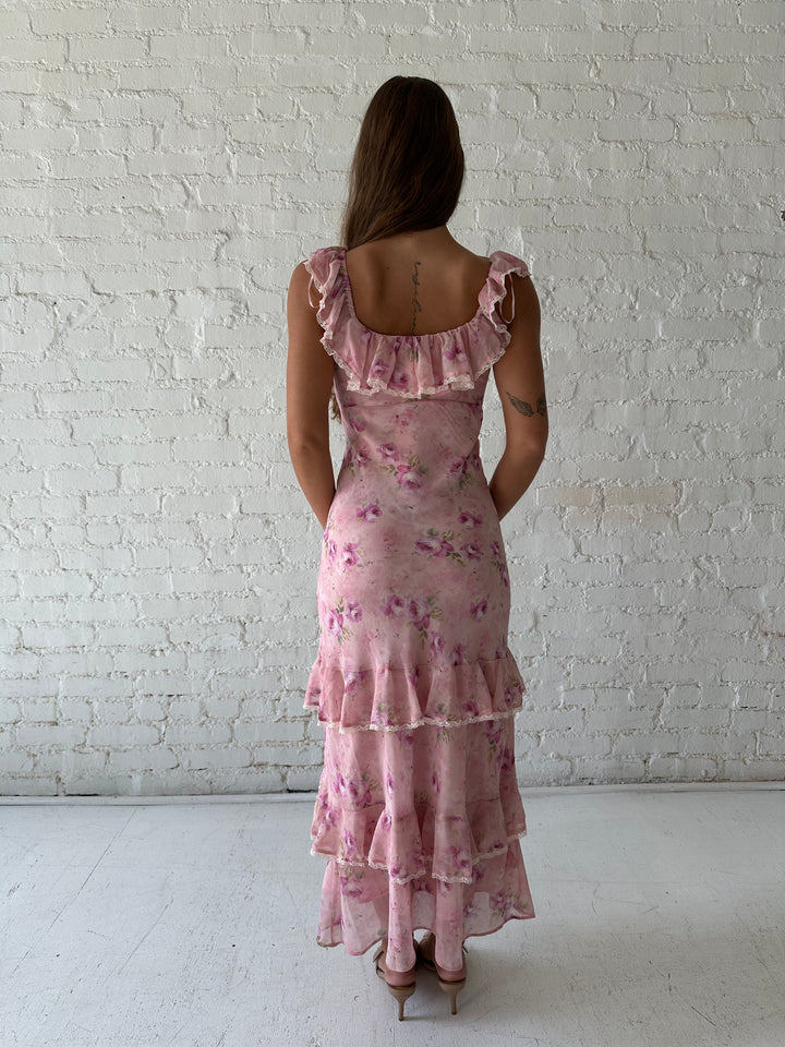 Woman wearing pink floral tiered maxi dress with lace trim detail.