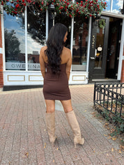 Woman wearing brown mini dress with front zipper closure, and collar neckline detail. 