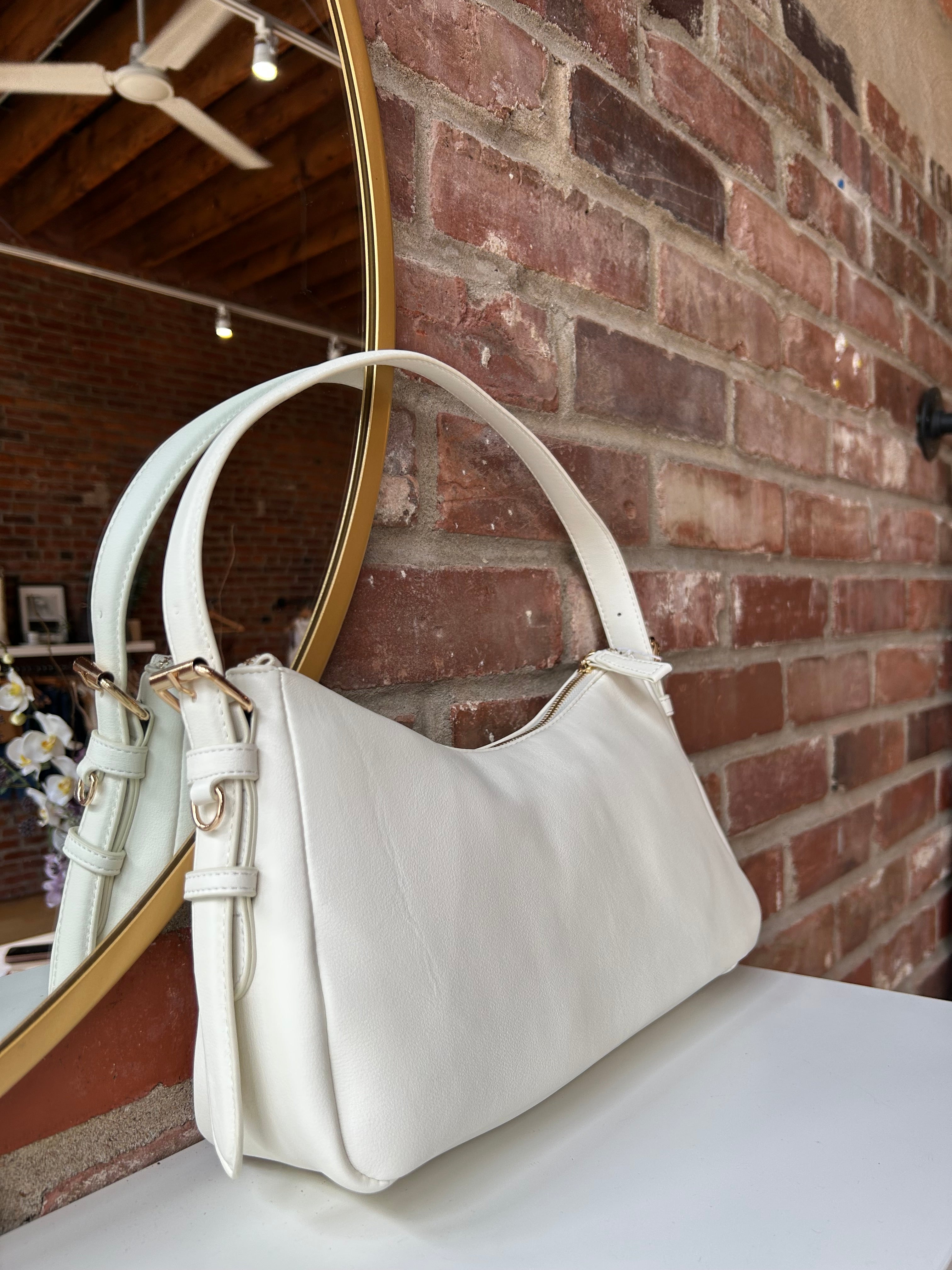 Bone leather shoulder bag with zip closure, sleek silhouette, and adjustable strap
