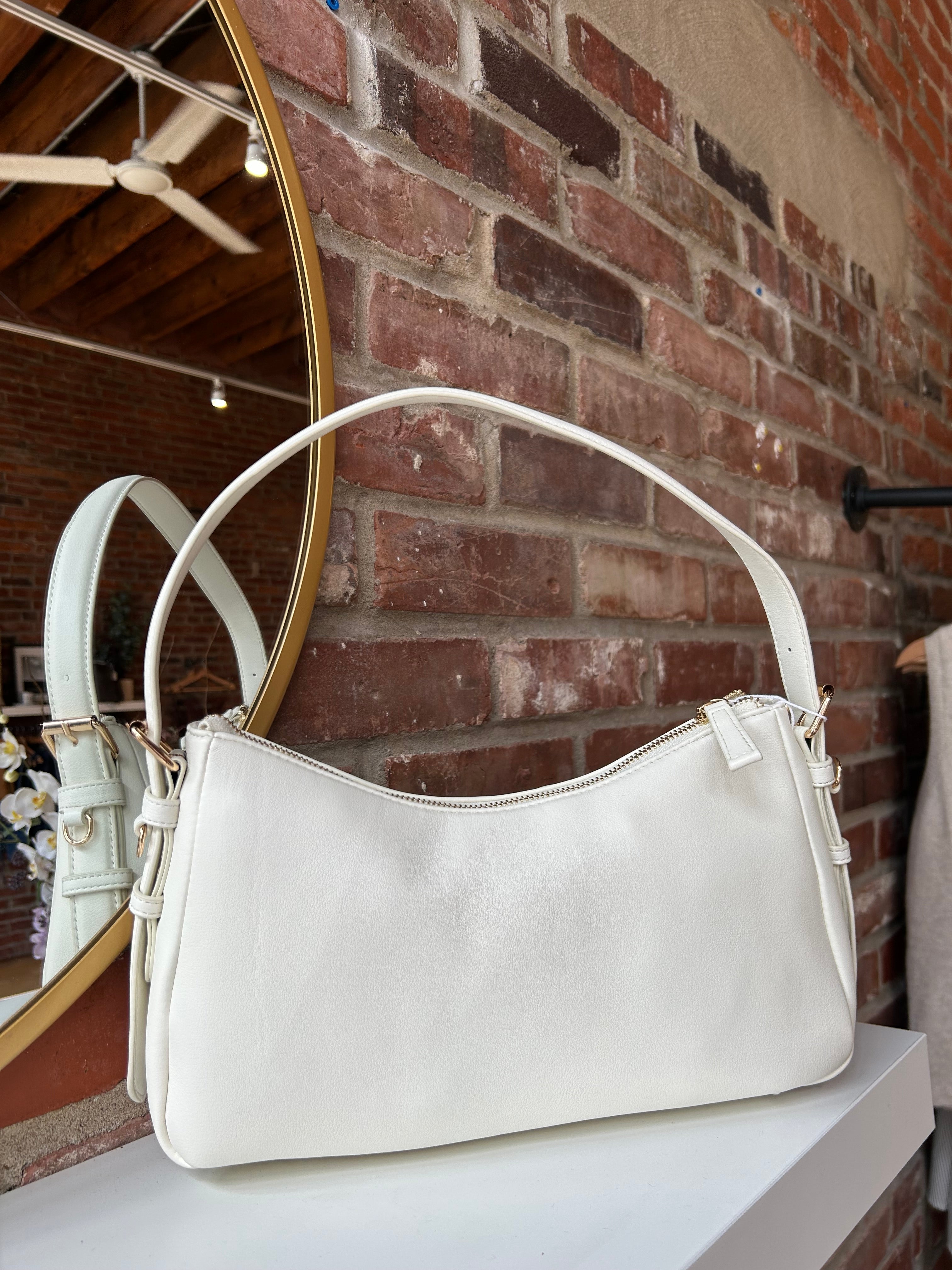 Bone leather shoulder bag with zip closure, sleek silhouette, and adjustable strap