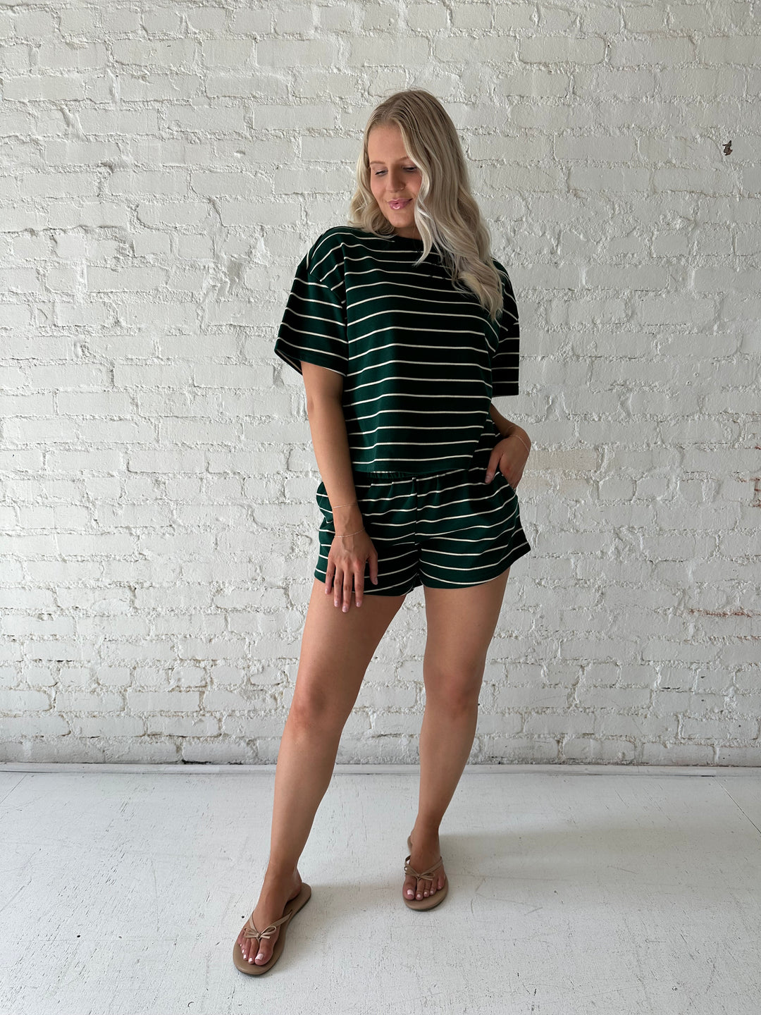 Woman wearing green and white striped two piece lounge set.