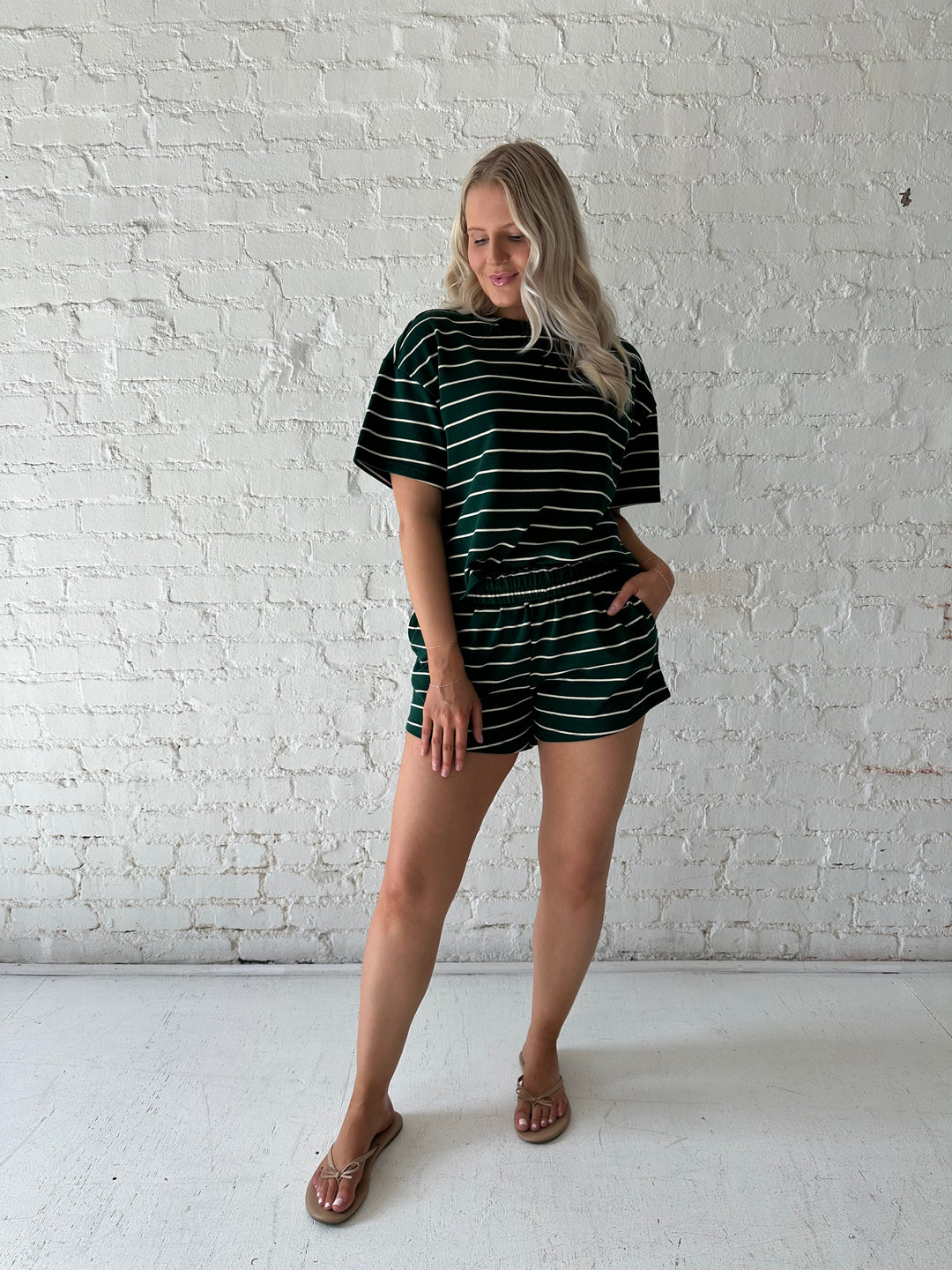 Woman wearing green and white striped two piece lounge set.