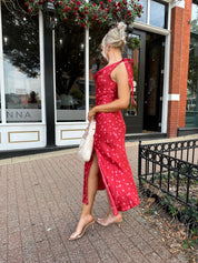 Woman wearing red cowl neck satin midi dress with polka dot pattern. 