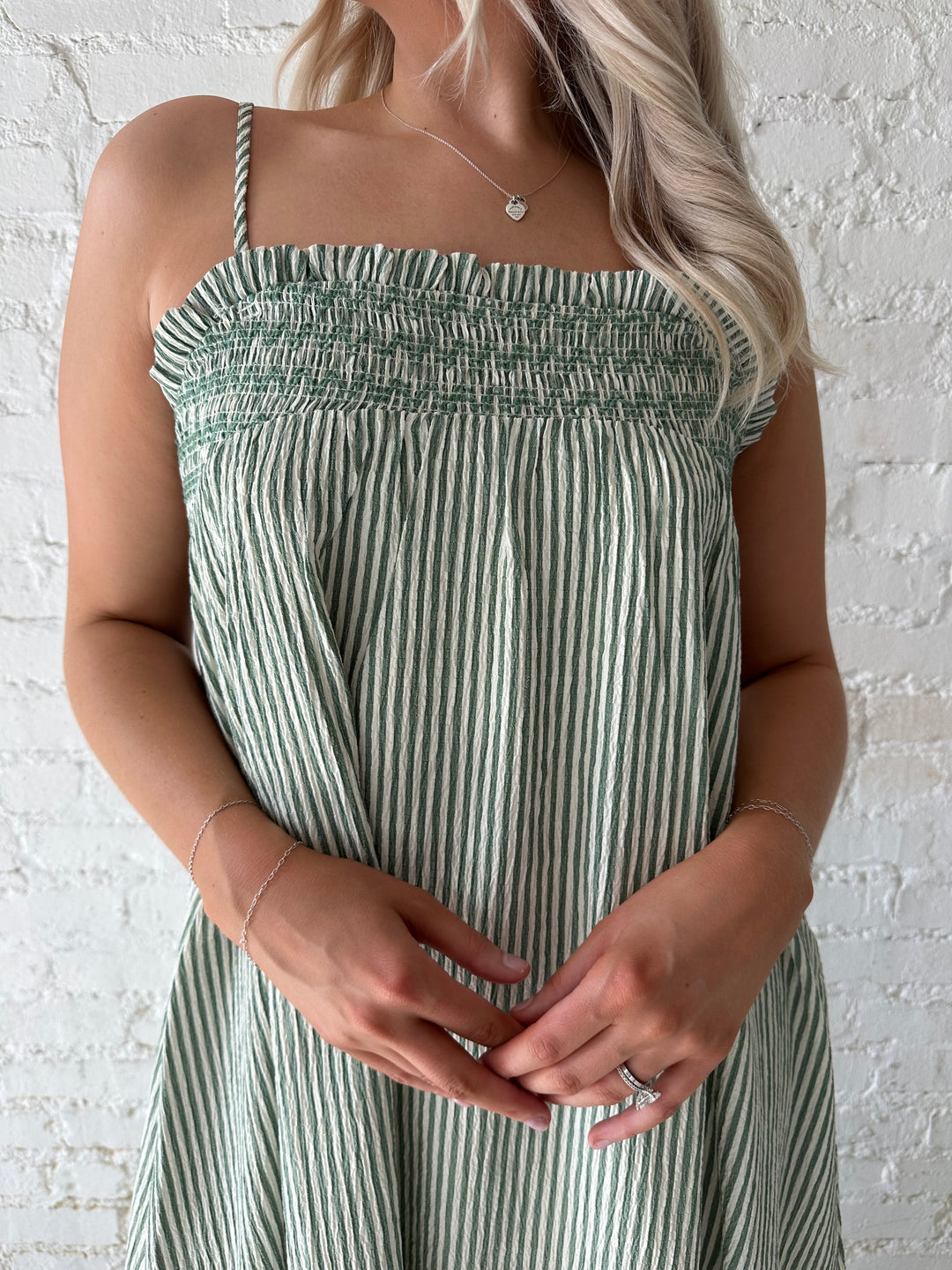 Woman wearing green striped tunic maxi dress with stitch gathering details. 