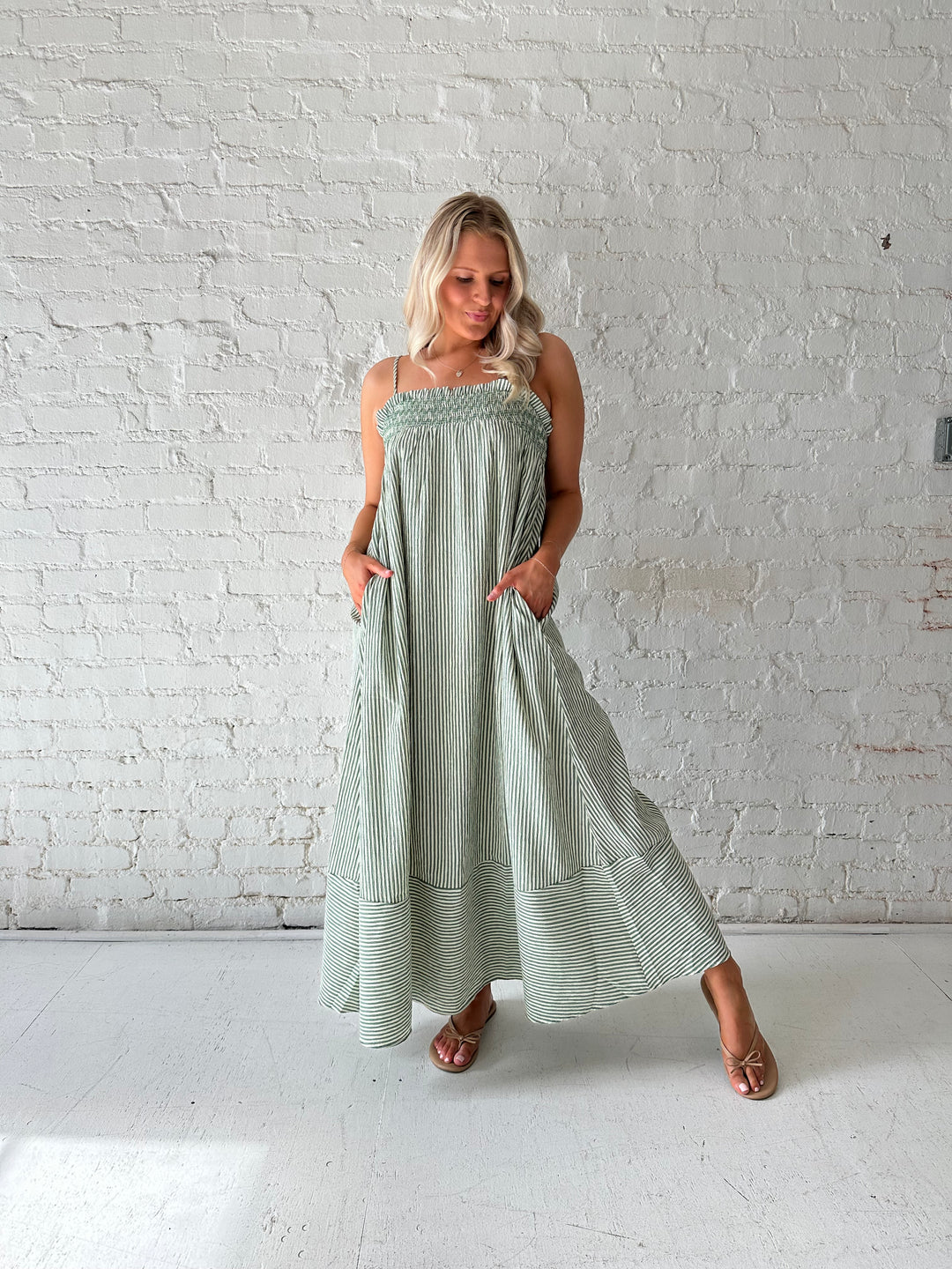 Woman wearing green striped tunic maxi dress with stitch gathering details. 