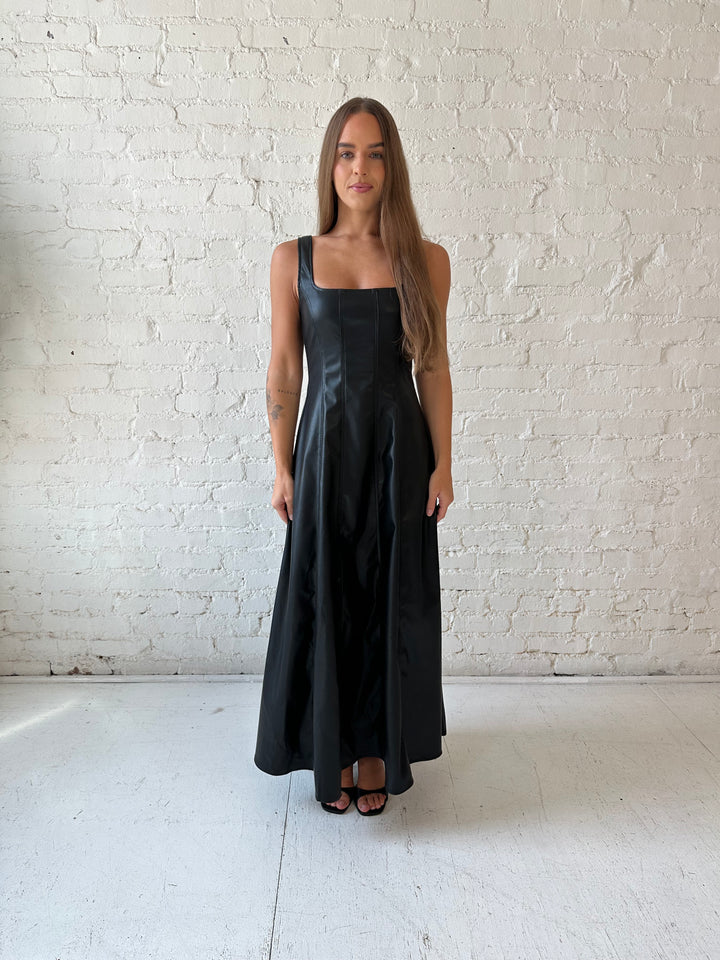 Woman wearing black faux leather flowy maxi dress with black heel.