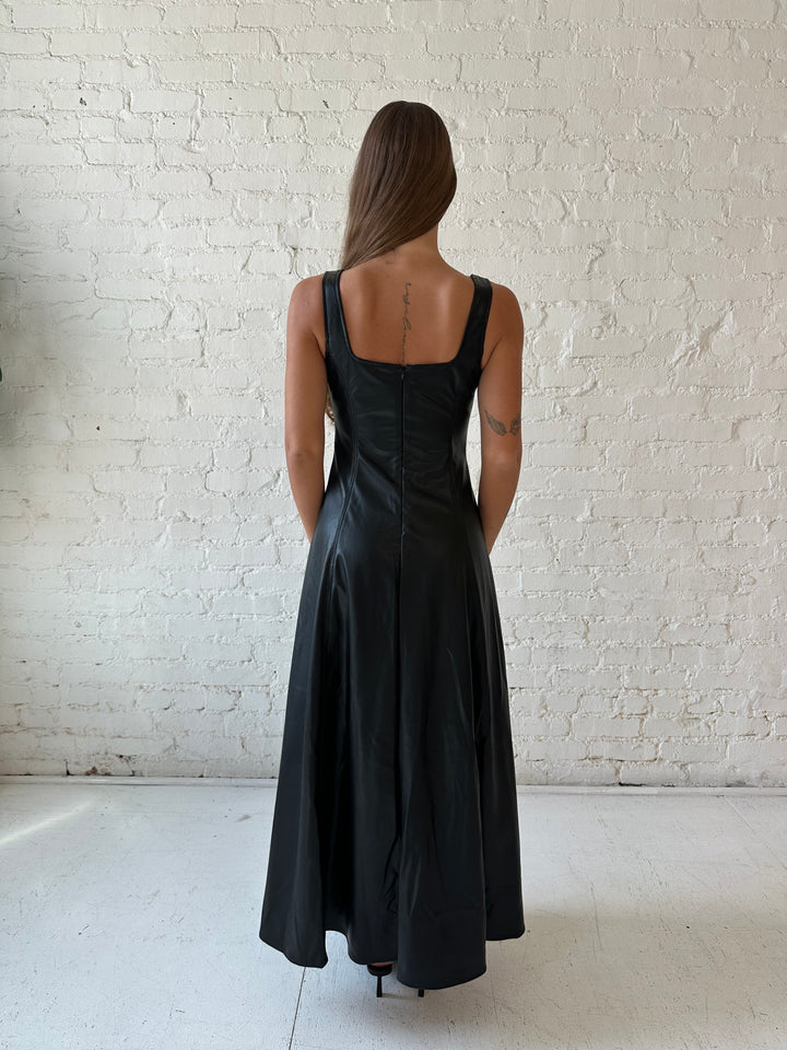 Woman wearing black faux leather flowy maxi dress with black heel.