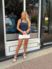 Dark wash denim peplum corset top with clasp closure.