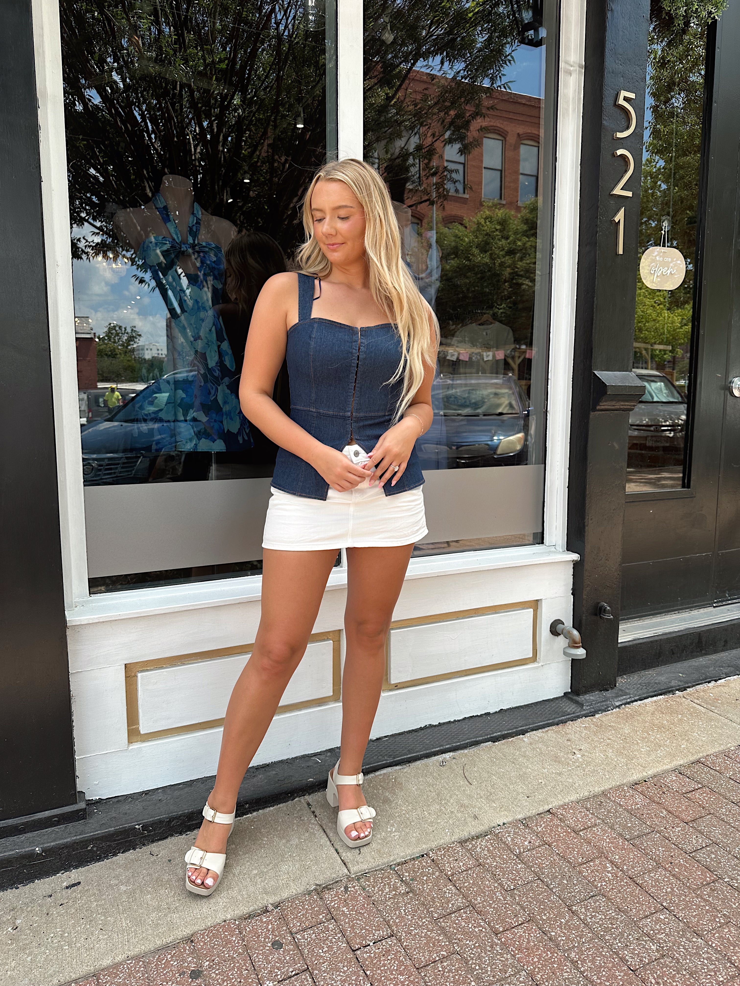 Dark wash denim peplum corset top with clasp closure.