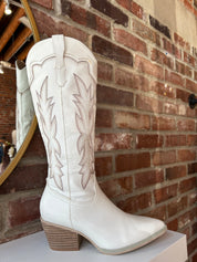White Western boot with brown stitching, pointed toe, and stacked block heel