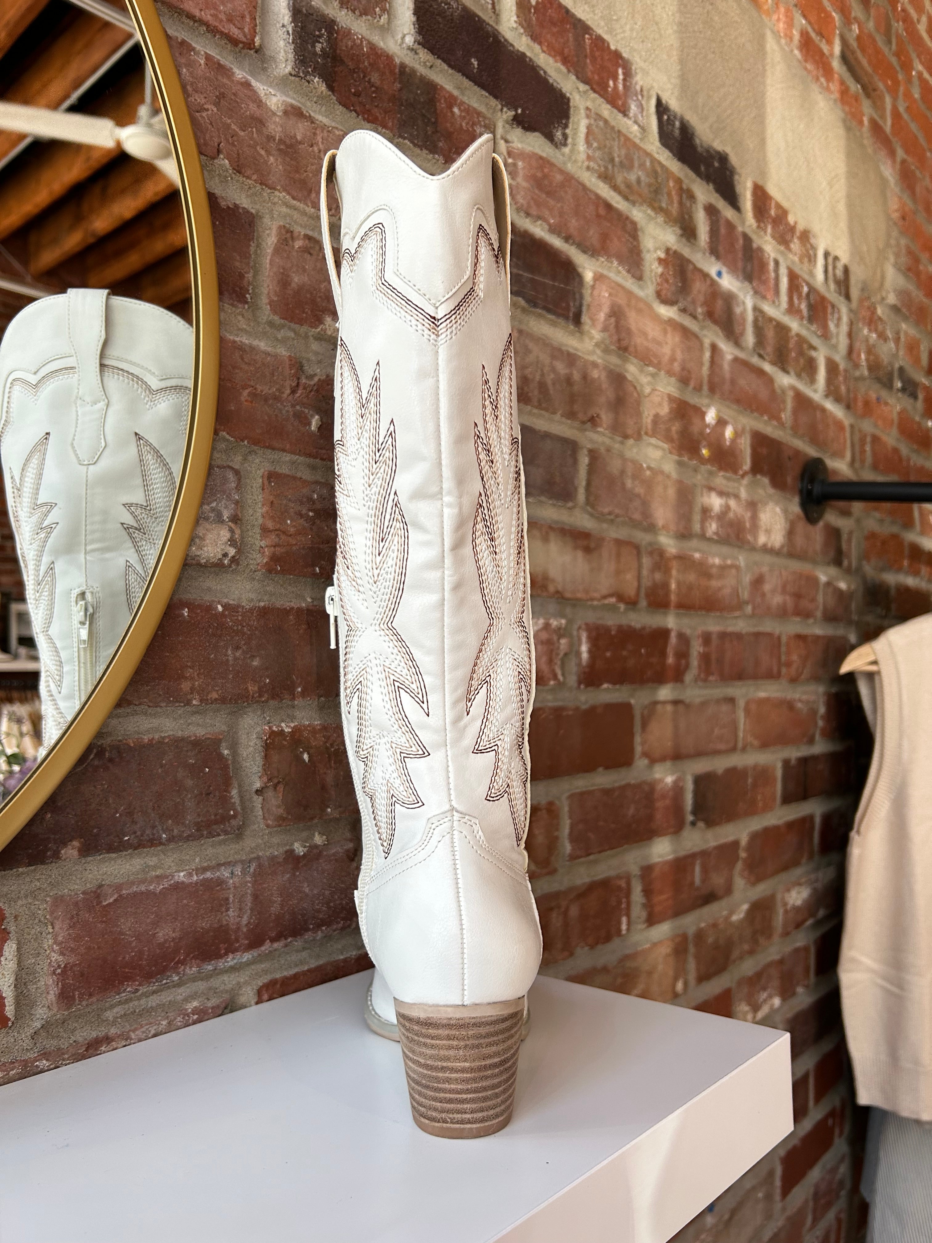 White Western boot with brown stitching, pointed toe, and stacked block heel