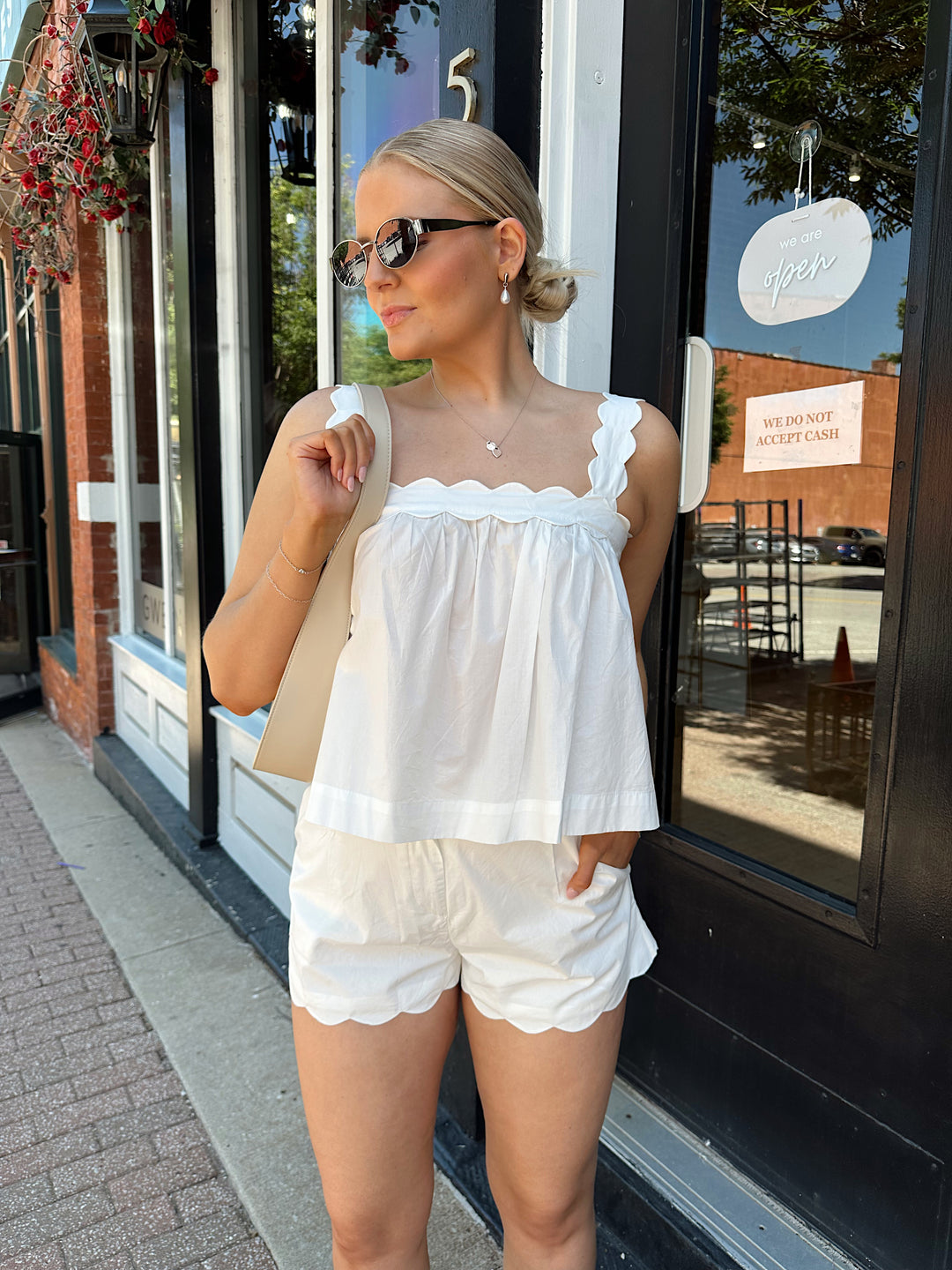 Woman wearing white light weight two piece set with scallop hem.