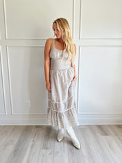 Beige striped midi dress with eyelet detailing and tiered skirt.
