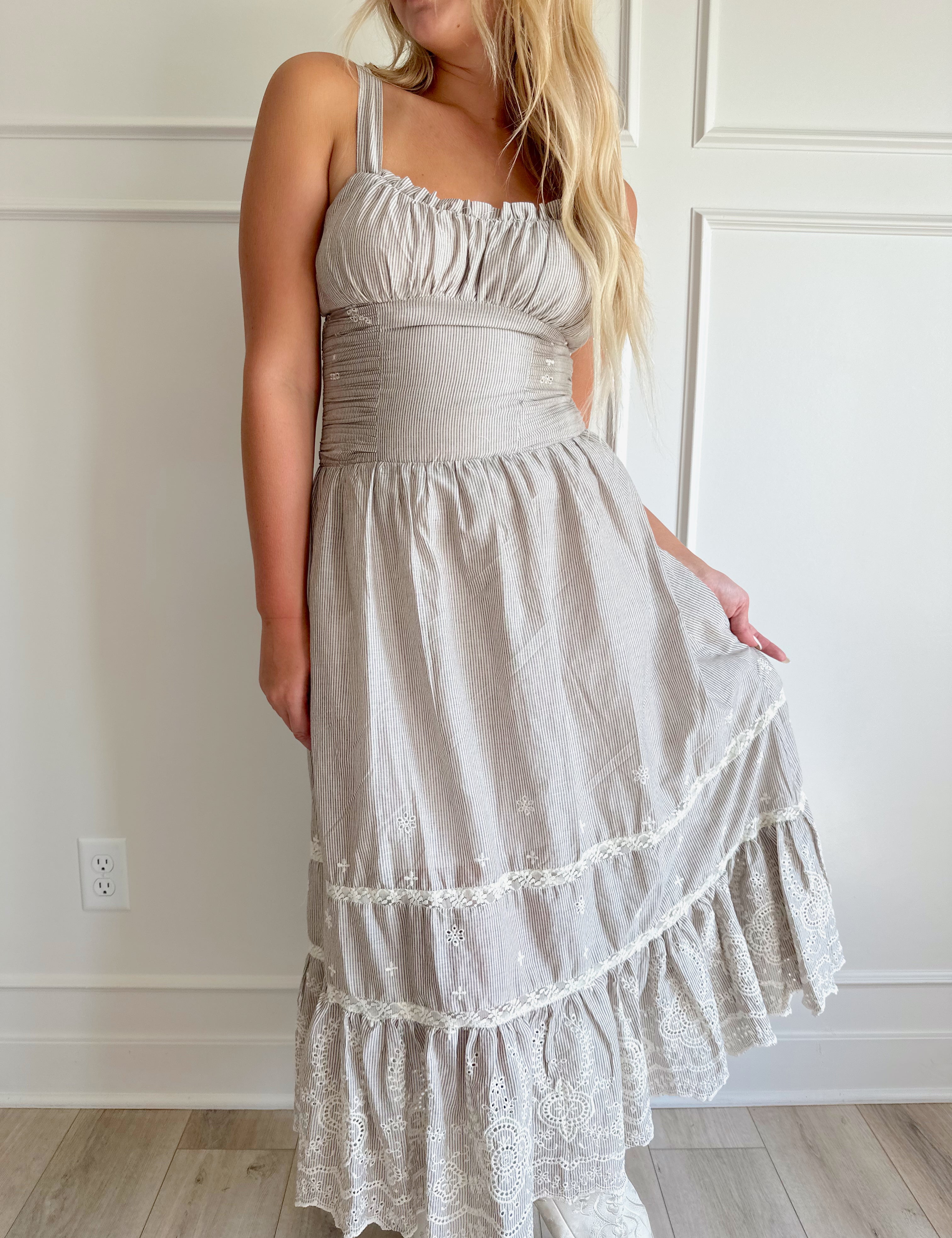 Beige striped midi dress with eyelet detailing and tiered skirt.