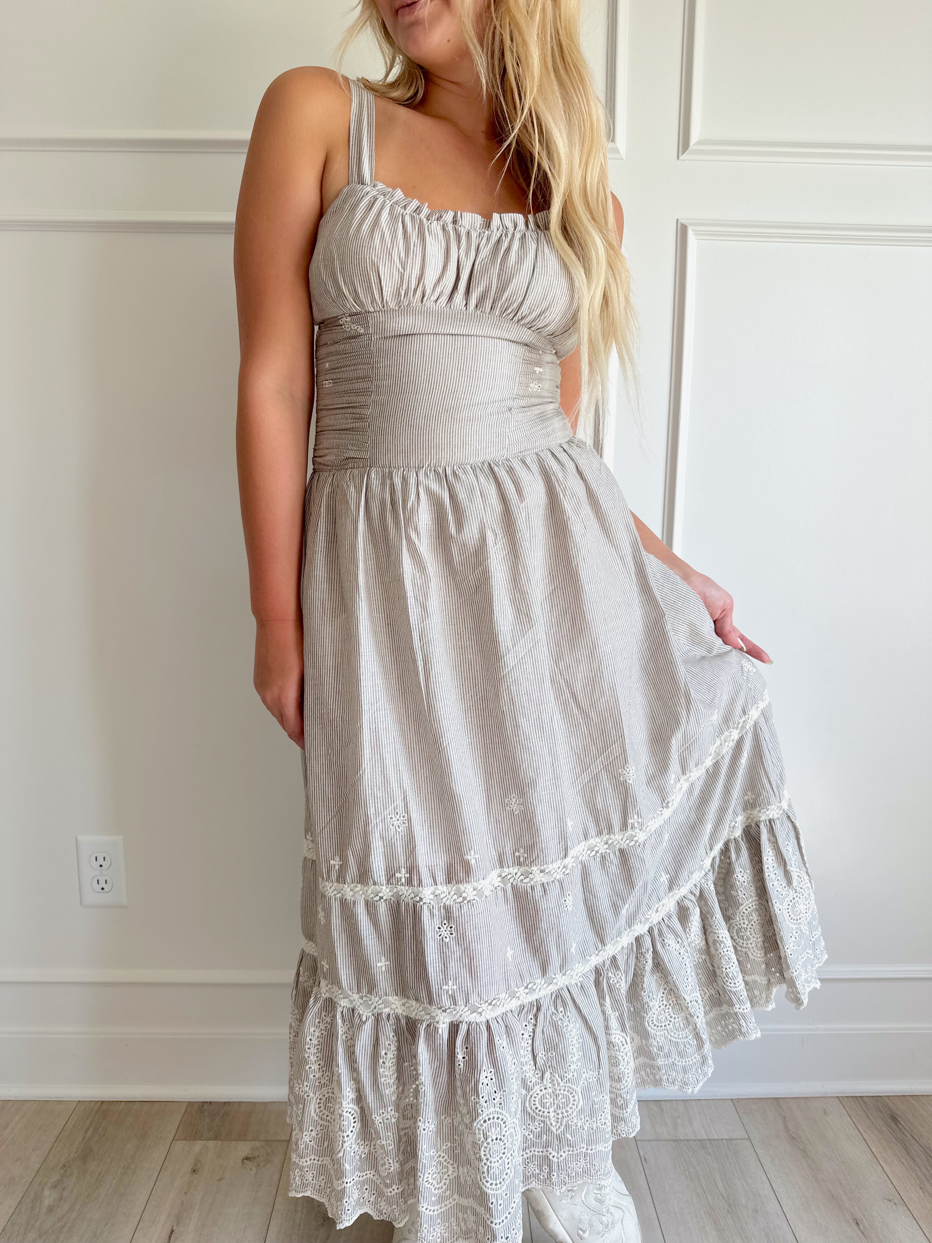 Beige striped midi dress with eyelet detailing and tiered skirt.