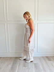 Beige striped midi dress with eyelet detailing and tiered skirt.