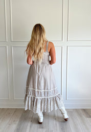 Beige striped midi dress with eyelet detailing and tiered skirt.