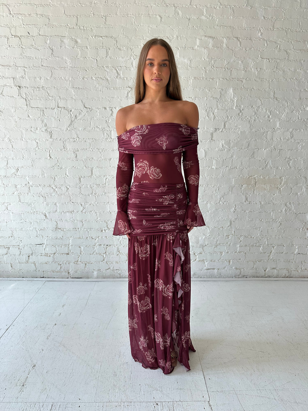 Woman wearing a purple floral mesh maxi dress with an off the shoulder neckline, and detachable scarf. 