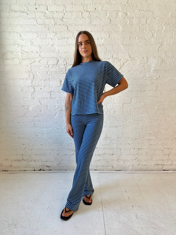 Woman wearing navy and blue striped two piece lounge set.