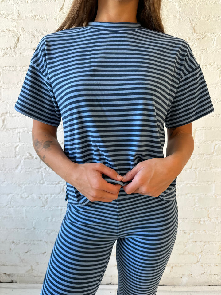 Woman wearing navy and blue striped two piece lounge set.