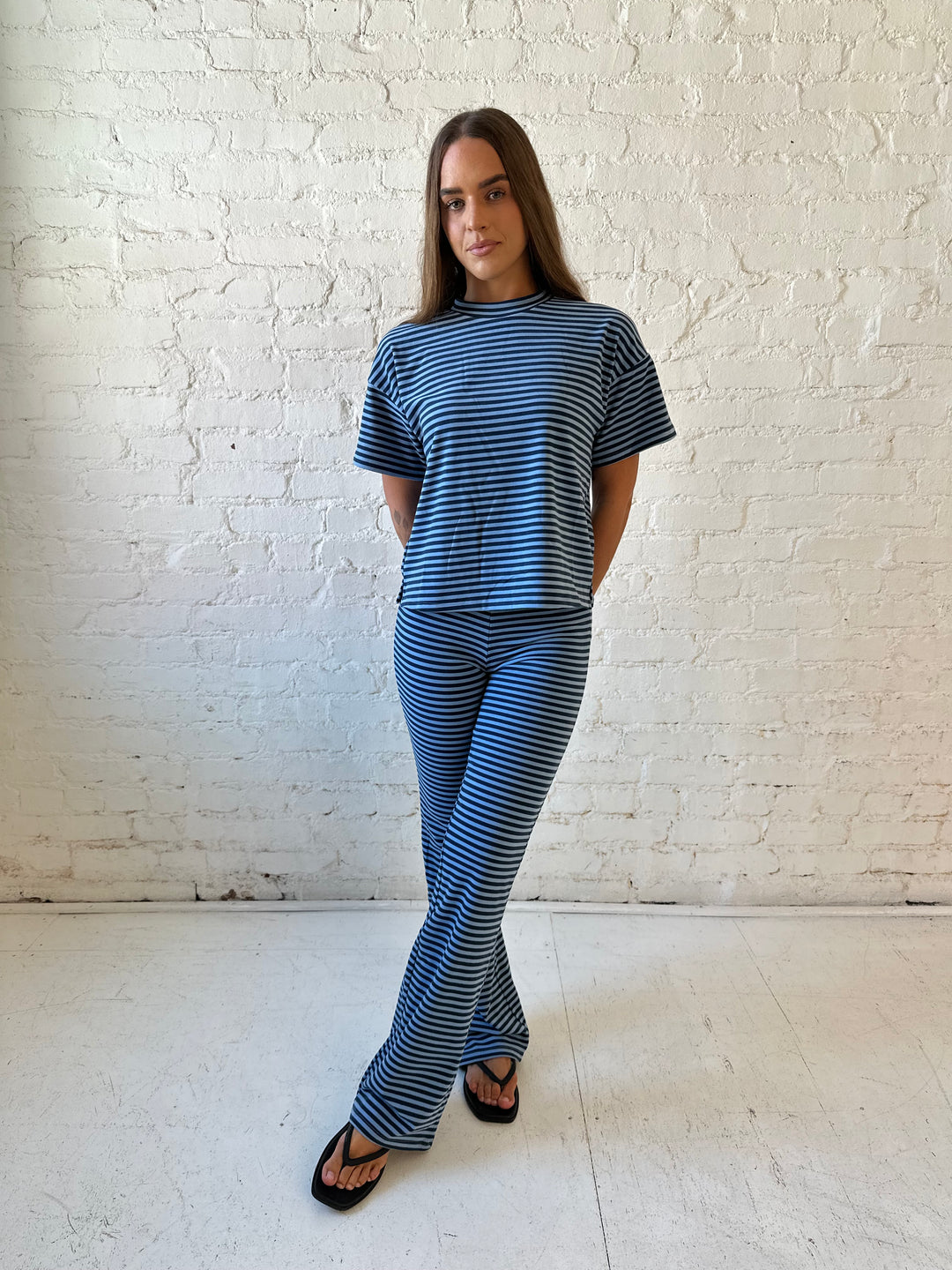 Woman wearing navy and blue striped two piece lounge set.