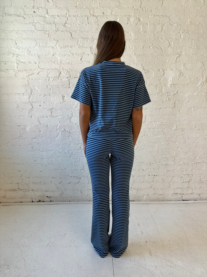 Woman wearing navy and blue striped two piece lounge set.
