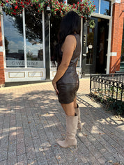 Woman wearing brown leather high waisted skirt with matching blazer. 