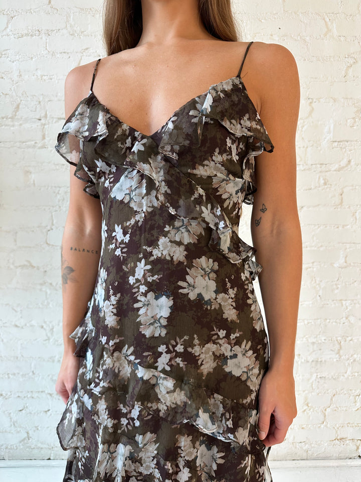 Woman wearing brown floral ruffle tiered maxi dress with adjustable spaghetti straps. 