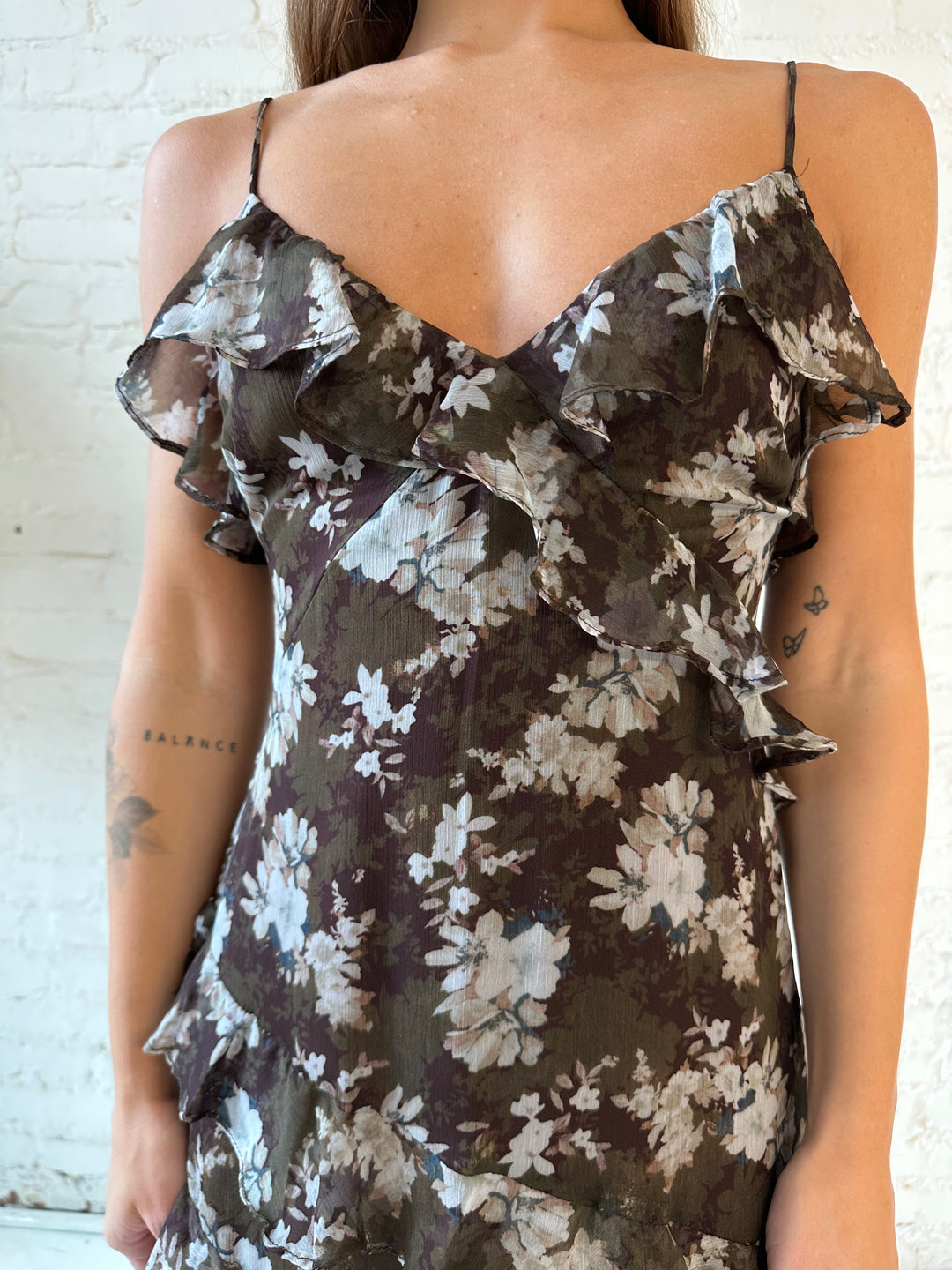 Woman wearing brown floral ruffle tiered maxi dress with adjustable spaghetti straps. 