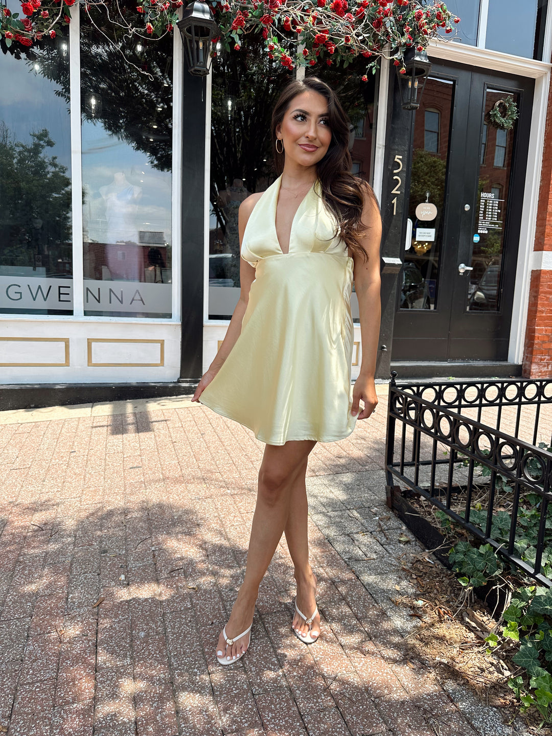Woman wearing yellow satin halter mini dress.