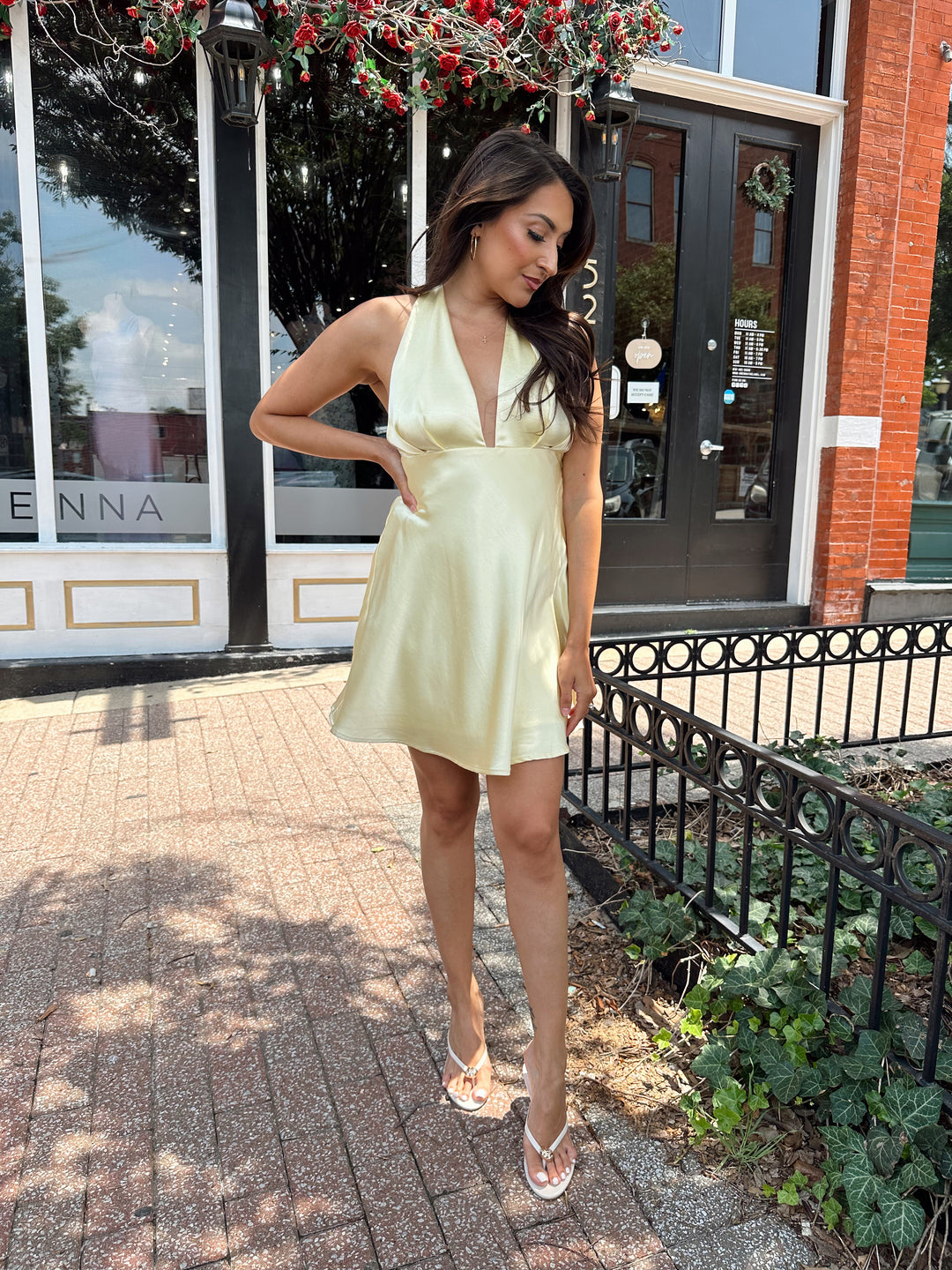 Woman wearing yellow satin halter mini dress.