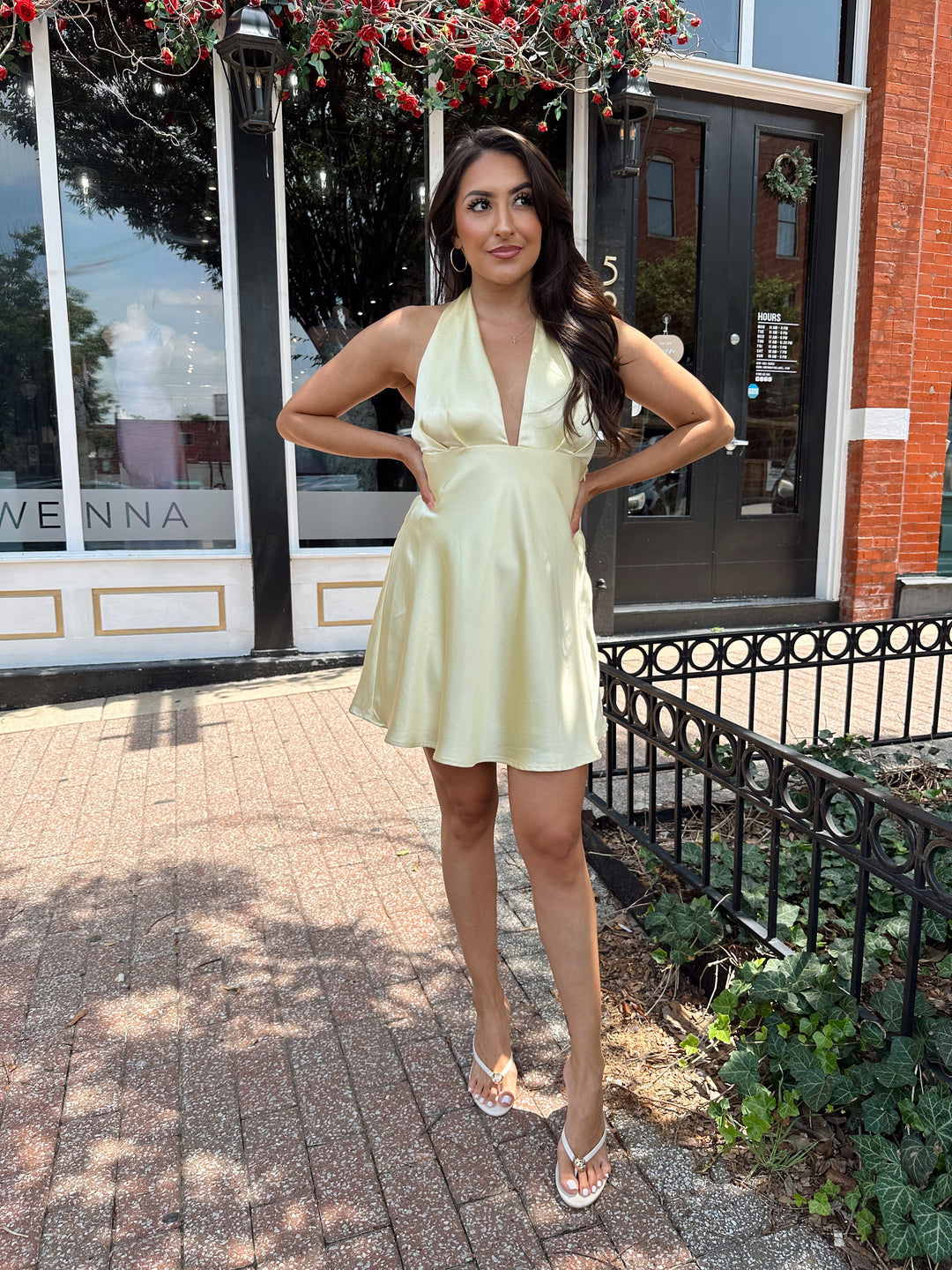 Woman wearing yellow satin halter mini dress.