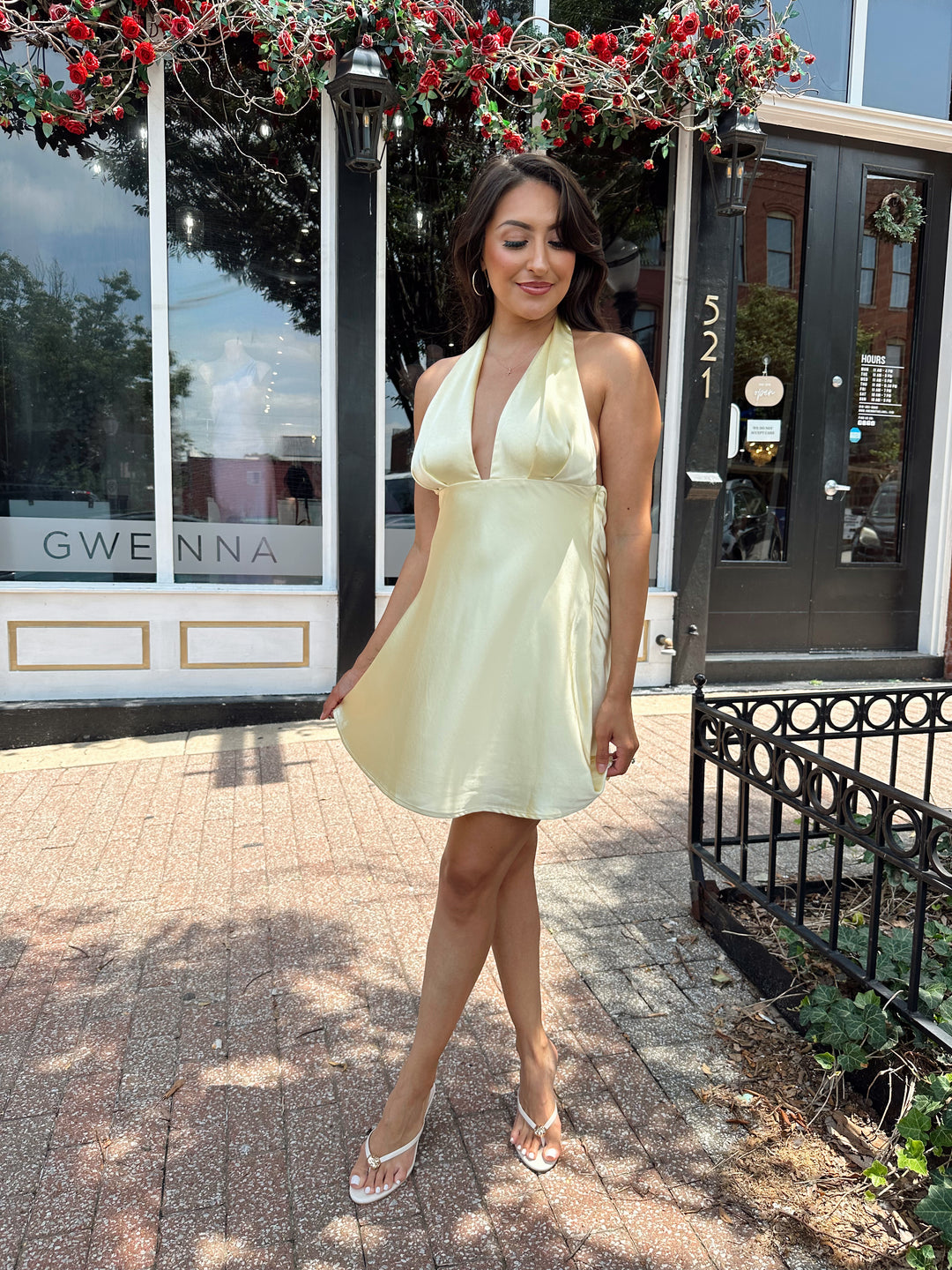 Woman wearing yellow satin halter mini dress.