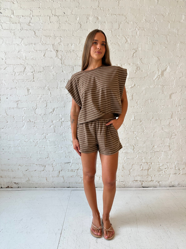 Woman wearing brown and tan striped two piece short lounge set. 